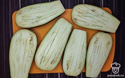 Баклажаны отделите от плодоножки и разрежьте пополам вдоль. На каждой половине баклажана сделай надрезы ножом и натрите солью. И оставьте их на 40-50 минут.