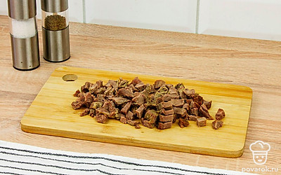 Мясо в процессе варки должно отойти от кости. Нарезать его на кусочки. Чеснок порезать мелко.