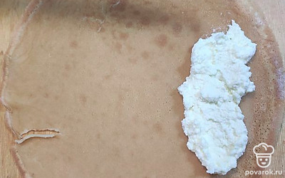 Когда все блины выпечены, приступайте к сборке. Кладём блинчик румяной стороной к себе, а светлой стороной вниз. На блин выкладываем начинку и сворачиваем конвертиком.