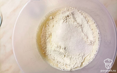 Далее добавить просеянную муку и сахар. Хорошо перемешать.
