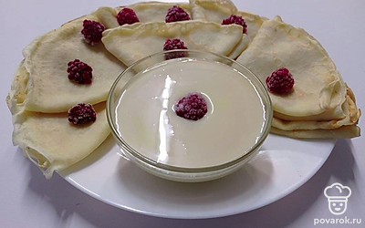 Готовое блюдо расположите на тарелке, украсьте ягодами и сгущенкой.