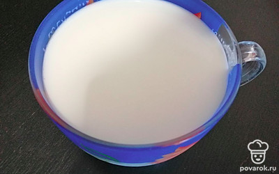 В отдельную чашку отличить часть молока, лучше чуть больше половины, тогда ингредиенты будет легче смешать, добавить соду.