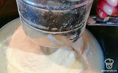 В кастрюлю с молоком добавить готовую смесь из яиц, масла и сахара, перемешать, добавить муку.