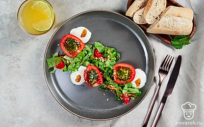 При подаче выложите фаршированные помидоры на блюдо, украшенное салатными листьями.