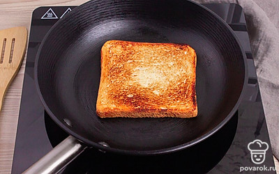 На сухой раскаленной сковороде обжарьте хлеб с двух сторон.