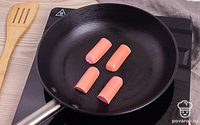 Сосиску разрежьте на 4 части и обжарьте на сковороде со всех сторон.