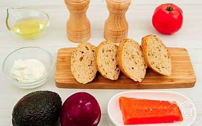 Приготовьте необходимые ингредиенты. Рыбу очистите от кожуры. Помидор и авокадо хорошо помойте. Лук очистите от кожуры. Багет нарежьте кусочками.