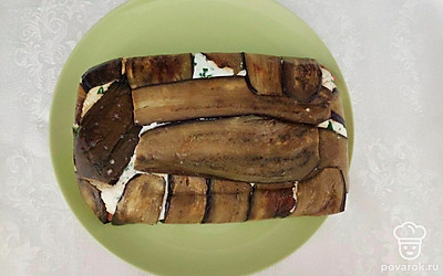 Уложите свисающие баклажаны сверху, затем покройте все пищевой пленкой, сверху желательно положить груз. Оставьте в холодильнике на несколько часов, затем слейте лишнюю жидкость, разверните пленку. Террин готов к употреблению.