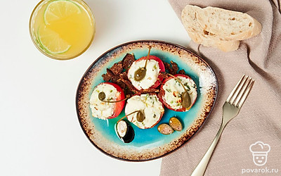 При подаче выложите фаршированные помидоры на блюдо, украшенное салатными листьями.