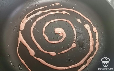 На разогретую сковороду из бутылки наливаем тесто. 