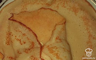 Положите яйцо на середину блина и сложите конвертиком. 