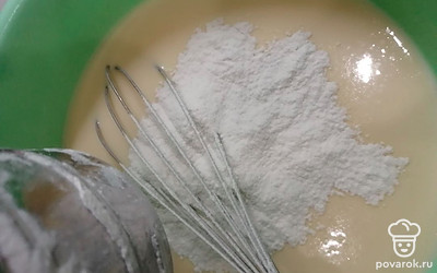 В эту смесь всыпаем просеянную муку. Всё хорошо перемешиваем, чтобы не было комочков. Тесто должно быть консистенции густой сметаны. 