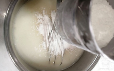 Частями добавляем просеянную муку, тщательно перемешиваем, чтобы не было комочков. 