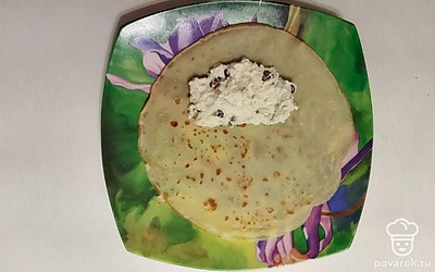 Выложите немного начинки на блин и заверните его краями внутрь в рулет.