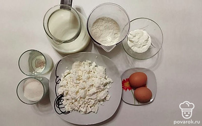 Отмерьте муку, сахар и сметану. Налейте молоко в кувшин. Выложите творог в тарелку. Подготовьте яйца и масло.