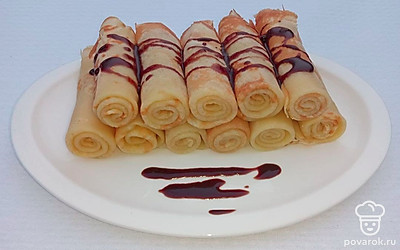 Из блинов сделайте трубочки и растопленным шоколадом или вареной сгущенкой чуть капните на завернутые блины.