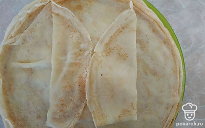 На край блинчика выложите столовую ложку начинки, накройте краем блинчика, и с двух сторон тоже сложите края блинчика и закрутите в трубочку. Готовые блинчики обжарьте на растительном масле с двух сторон до румяной корочки.