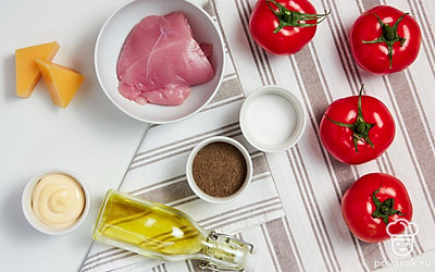 Филе индейки ополосните и нарежьте некрупными пластинками. Помидоры помойте и обсушите полотенцем. Аккуратно вырежьте сердцевину и достаньте мякоть. Сыр натрите на крупной терке. Разогрейте духовку до 200 градусов. Противень для запекания смажьте растительным маслом.