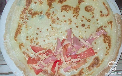 Блины жарьте на среднем огне с обеих сторон. Для начинки сыр натрите на терке, ветчину нарежьте тонкими ломтиками. Помидоры также. Начинку смешивайте. Затем накладывайте на блинчик и закручивайте конвертом.