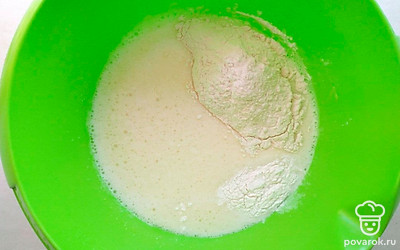 В глубокую тарелку вбейте яйца и всыпьте сахар и посолите. Взбейте миксером или венчиком до образования пенки. Влейте молоко и воду и постоянно помешивая засыпьте муку смешанную с разрыхлителем. Хорошо перемешайте тесто. До однородности и добавьте растительное масло.