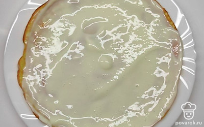 Готовые тонкие блинчики промажьте лопаткой или ложкой плотным кремом, который готовится из смеси всего двух ингредиентов – сметаны и сгущенного молока. Блины выкладывайте друг на друга. В конце верх и бока будущего торта щедро смажьте остатками крема.