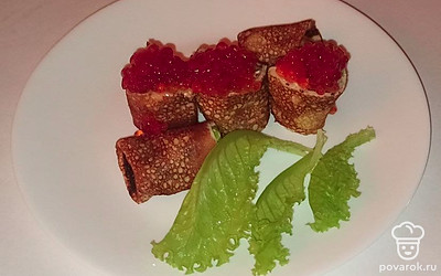 Блинчики разделите на порции и отправьте их на тарелки. Украсьте каждую листьями салата и подайте к столу.