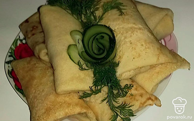 Готовые блинчики аккуратно сверните конвертиками и выложите красиво на тарелку. Украсьте зеленью и малосольным огурчиком. Подайте в таком виде к столу.