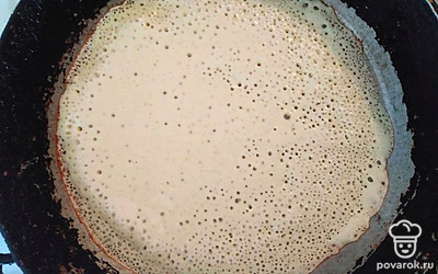 На раскаленную сковороду половником налейте получившееся тесто, при этом распределяя его по всему дну тонким слоем. Обжаривайте на среднем огне до румяности краев. Затем переверните блин и дайте ему еще 1-2 минуты на огне. Проделывайте данную операцию пока не закончится тесто.