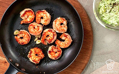 Приготовьте начинку. Смажьте сковороду маслом, разогрейте ее, положите креветки и обжаривайте их с обеих сторон несколько минут. Авокадо вместе с чесноком поместите в блендер и перебейте до пюреобразного состояния. Добавьте творожный сыр, лимонный сок, поперчите, посолите. Тщательно все перемешайте.