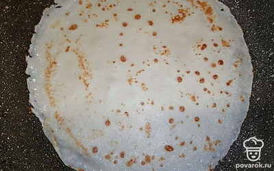 Приступайте к обжариванию блинчиков на среднем огне. В разогретую сковороду залейте треть половника с блинным тестом. Обжаривайте по пару минут с каждой стороны, до того момента, когда блин пропечется.