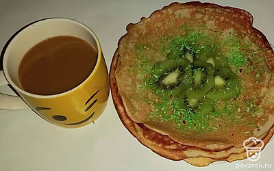 Блинчики уложите в тарелку стопкой и украсьте кокосовой стружкой и ломтиками киви. Подайте к столу с теплым напитком.