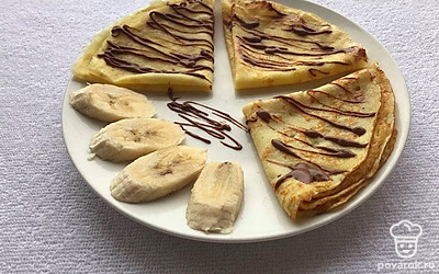 Подавайте теплыми, на красивой тарелочке, сложив их. Нарежьте банан и полейте глазурью блины.