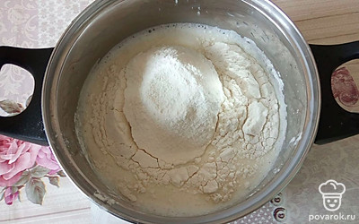 Добавьте просеянную муку и щепотку соли, тщательно перемешайте.