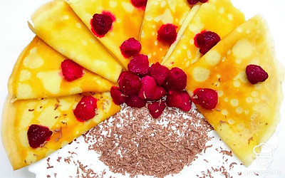 Готовые блины разложите по блюду, украсьте их шоколадом и ягодами.