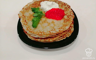 Готовые блины сложите в стопку и украсьте красной икрой, сметаной и веточкой петрушки.