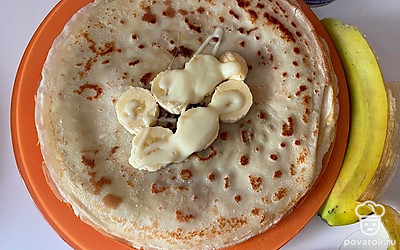 Банан нарезаем на кружочки и кладем в середину блина. Поливаем сгущенным молоком и заворачиваем блин как конверт. Готово!