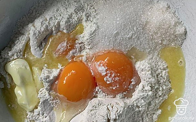 В муку добавляем желтки, соль, сахар, масло и перемешиваем.