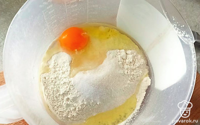 Добавьте молоко, яйцо и сахар и перемешайте. Добавляйте воду и доводите до констинстенции жидкой сметаны.