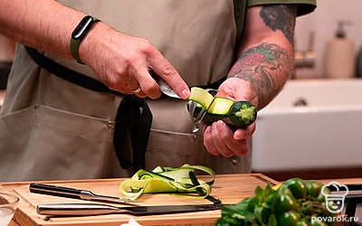 Цуккини нарежьте овощечисткой на тонкие ломтики. Выложить их в плоскую форму и обильно присыпьте солью со всех сторон. Дайте постоять в холодильнике в течение 15-20 минут, затем промойте под проточной водой. Просушите цуккини салфеткой и выложите ломтики на тарелку.