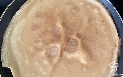 Разогреваем сковородку и выливаем половник теста на нее, распредиляем по всей сковороде, обжаривая блинчик с двух сторон до румяности.