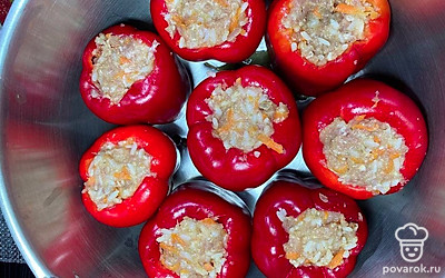 Наполните перцы получившейся начинкой. На дно кастрюли налейте растительное масло, добавьте лавровый лист и перец горошек. Заполните кастрюлю фаршированный перцем, залейте кипятком и отправьте на плиту до закипания. После закипания добавьте томатную пасту, накройте крышку и тушите 40 минут.