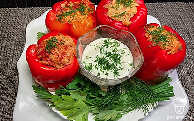 Готовый перец отправьте на порционную тарелку, присыпьте нарубленной зеленью петрушки или укропа, и подавайте с ложкой густой сметаны.