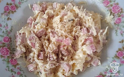 Для начинки мелко режем копченую колбасу, натираем на терке сыр и чеснок. Все перемешиваем и заправляем майонезом. Для большей остроты перчим черным перцем. Добавляем в начинку зелень.