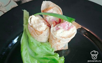 Подаем к столу, нарезав порционно небольшими рулетиками. Сверху украшаем зеленью.