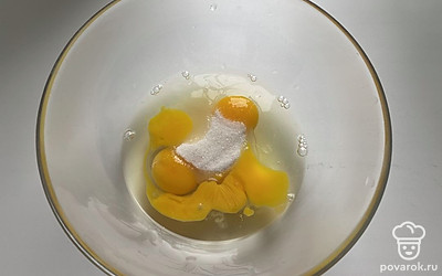 В глубокую миску разбить яйца, добавить к ним сахар и соль и хорошо взбить вилкой.