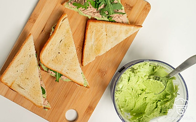 Подсушите хлеб. Разрежьте куски хлеба пополам на треугольники. Сбрызните их растительным маслом и подержите в разогретой до 180 градусов духовке 3-4 минуты. Достаньте из печи и остудите. На половину остывших ломтиков намажьте пюре из авокадо, сверху выложите печень трески и листья руколы. Прикройте оставшимися половинками хлеба.