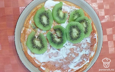 Готовый блин смазать сметаной. На одну половинку блина выложить кусочки киви, закрыть второй половинкой. 
