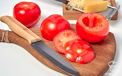 Займитесь помидорами. С томатов острым ножом срежьте верхний пласт. Соскоблите мякоть, не нарушая целостность стенок. Переверните получившиеся бочонки вверх дном на бумажное полотенце, чтобы стек лишний сок.