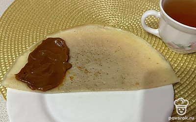 На один край блинчика кладем сгущенное молоко. Сворачиваем жгутиком.