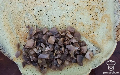 Выложить начинку из грибов на блин. Свернуть блин в форме рулета или конверта.